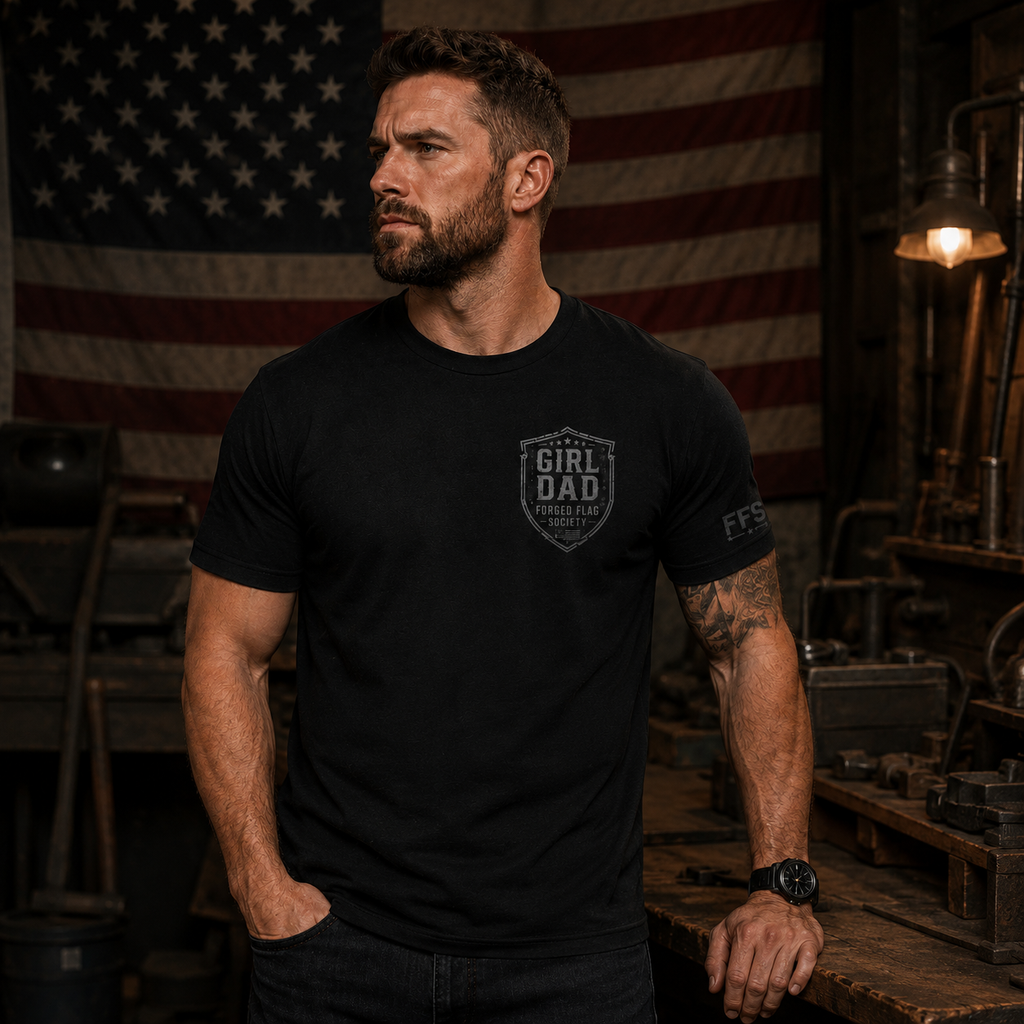 Man wearing a black t-shirt with a logo in front of an American flag